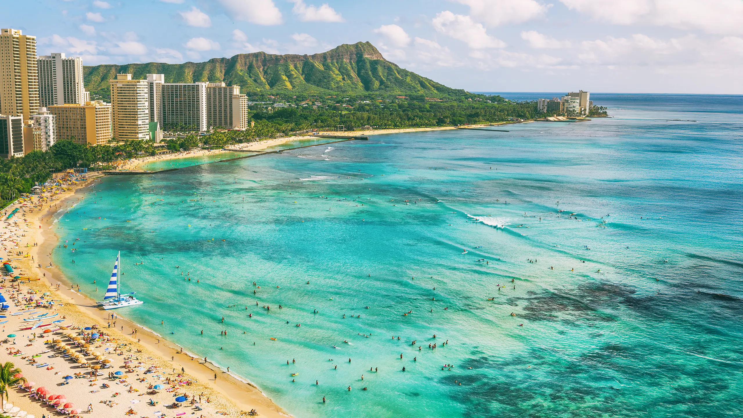 Waikiki surf spots near Canoes with Diamond Head in the background showing calm beginner friendly waves and clear turquoise water.